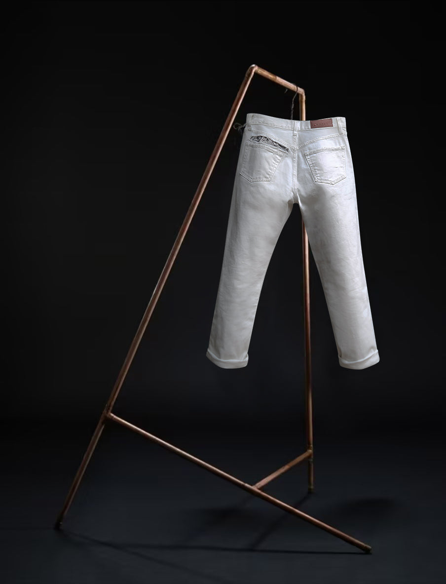 "B O R O デニム (BORO DENIM) 'Osaka Going Down South' washed off-white jeans hanging on a rack. The image emphasizes the Japanese Selvedge fabric and vintage appeal, presented against a black background with a back-side view."