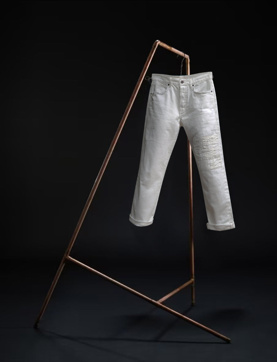 "B O R O デニム (BORO DENIM) 'Osaka Going Down South' washed off-white jeans hanging on a rack. The image emphasizes the Japanese Selvedge fabric and vintage appeal, presented against a black background with a front-side view."