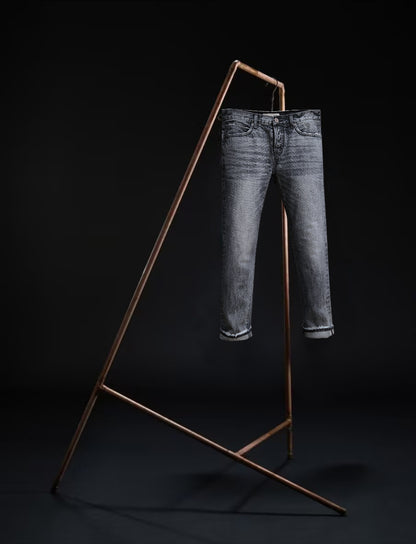 B O R O デニム (BORO DENIM) 'Sapporo All Eyes on Me' jeans hanging on a rack, showcasing the premium Japanese Selvedge fabric and genuine vintage charm, set against a black background, displaying the front side.