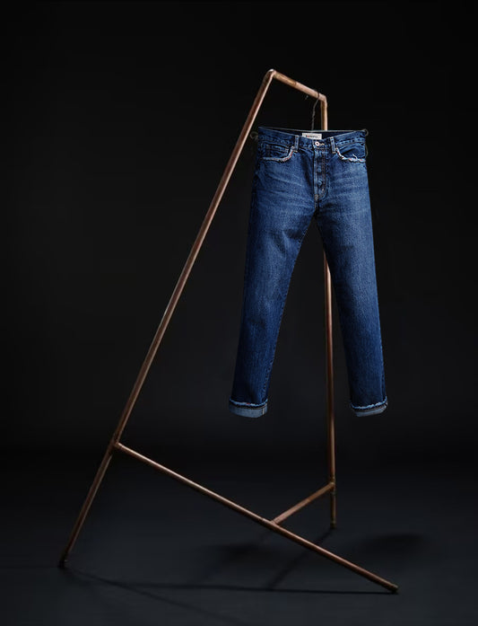 Tokyo jeans by B O R O デニム (BORO DENIM) in the 'Eagle Birds' colorway, elegantly hanging on a rack. The front side is displayed, emphasizing the premium Japanese Selvedge fabric and the authentic mid-blue vintage wash, set against a black backdrop.