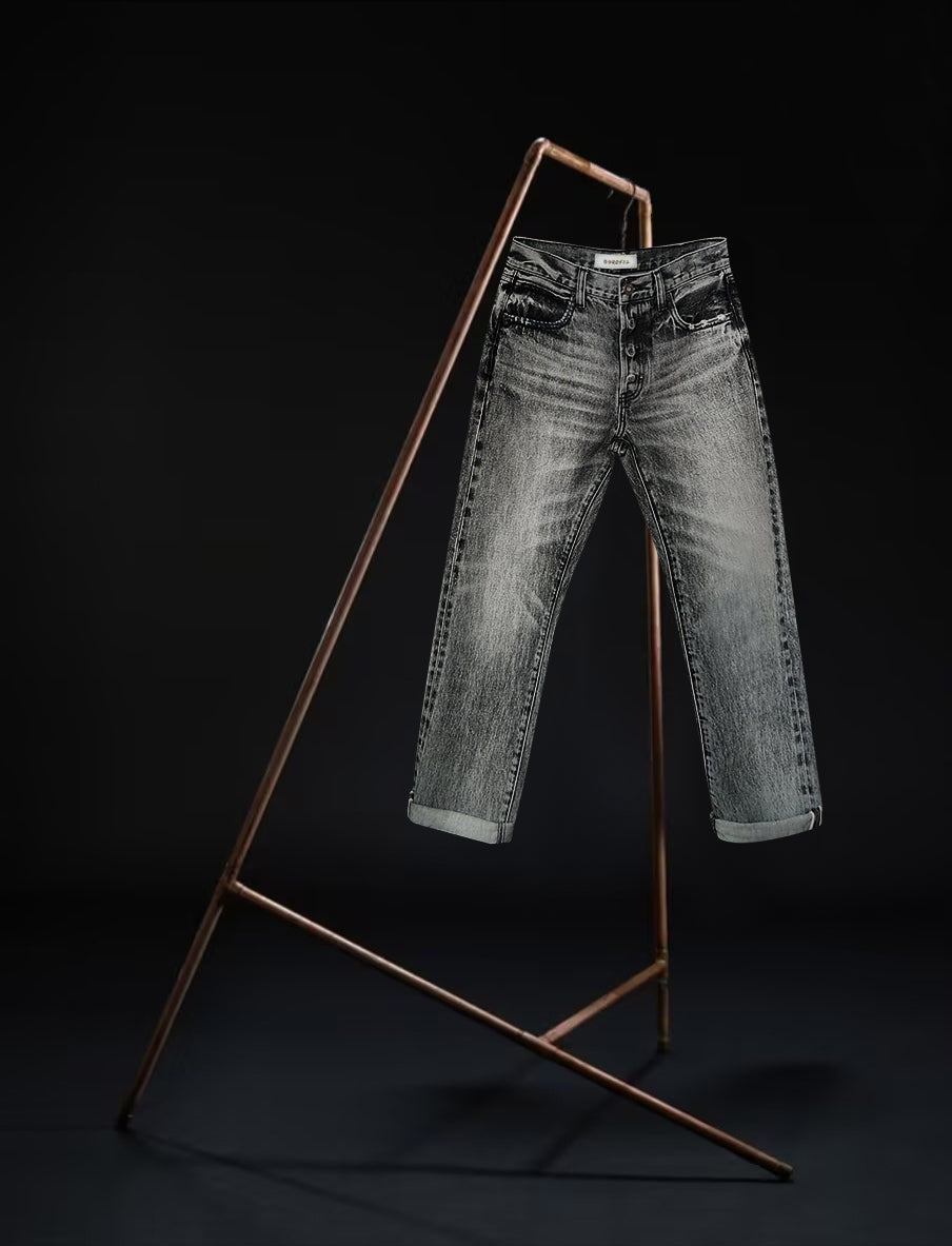 Front view of the B O R O デニム (BORO DENIM) 'Osaka Deep in the Heart' washed black jeans displayed on a rack against a black background. These jeans highlight the premium Japanese Selvedge Fabric and their distinctive vintage character