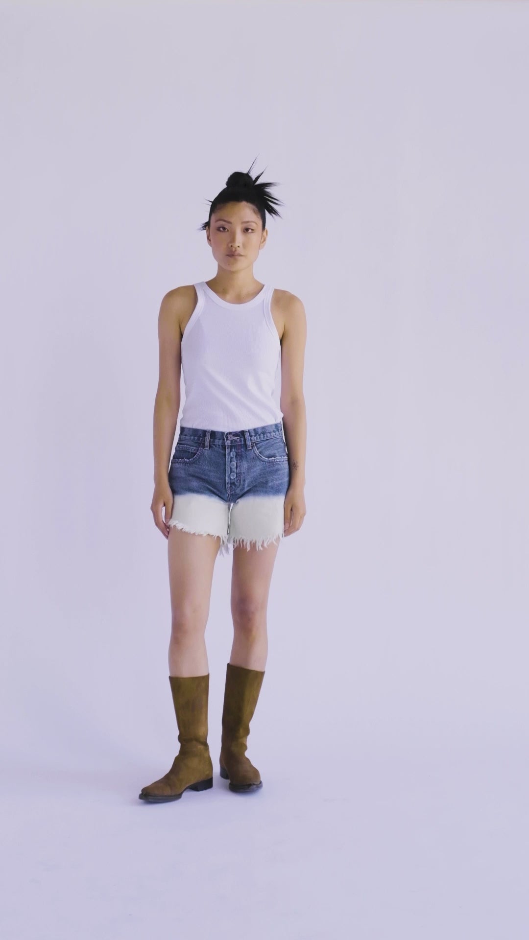 10-second video of a model presenting the B O R O デニム (BORO DENIM) 'Nagoya Let it Bleed' denim shorts. The model begins facing forward and rotates to showcase the shorts' unique 2-tone bleached ombre effect on Japanese Selvedge Fabric, from front to back