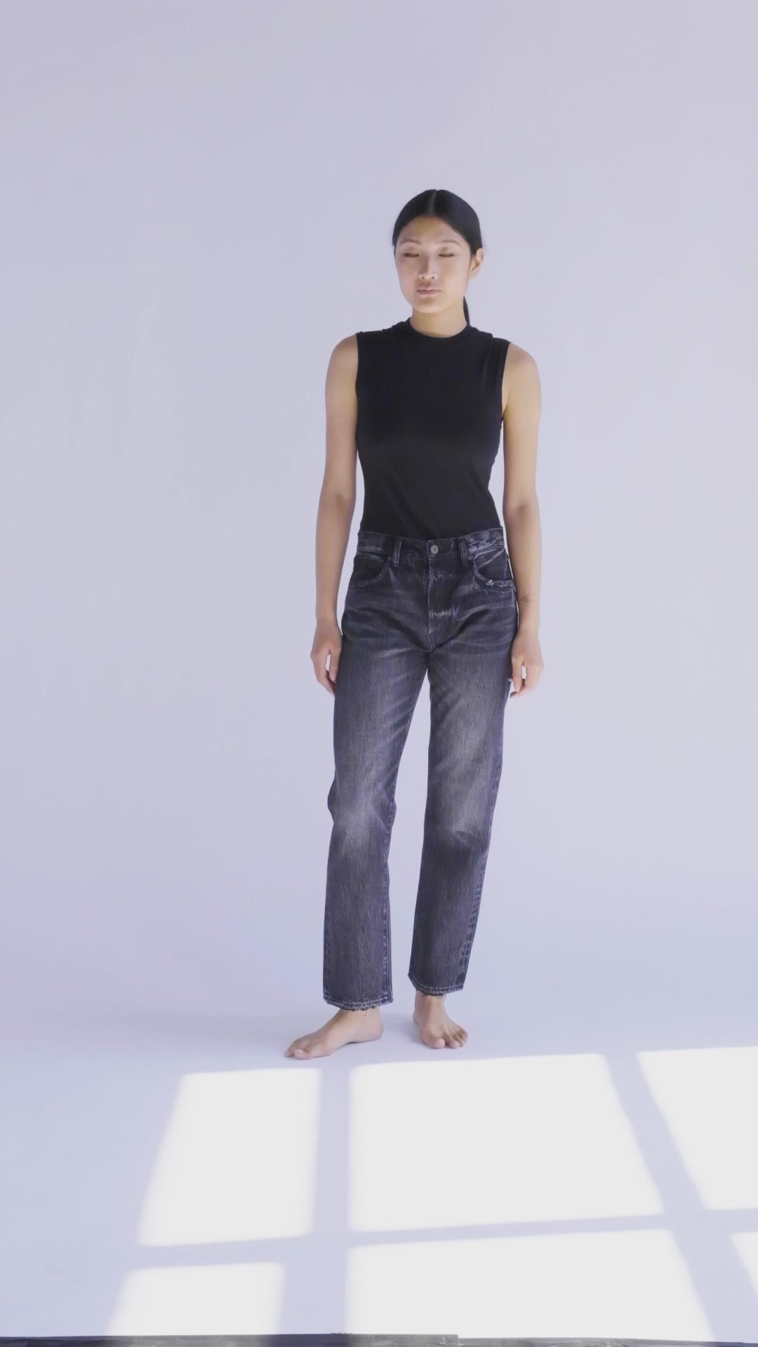 10-second video featuring the fit model in the B O R O デニム (BORO DENIM) 'Paint it Black' Tokyo jeans. The model gracefully makes a full 360-degree turn to showcase the jeans' mid-rise, straight-leg silhouette, emphasizing both the front and back views