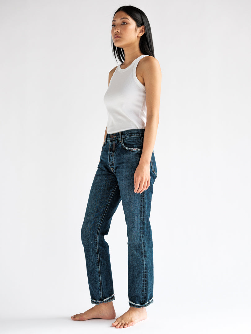 Side view of the fit model wearing the B O R O デニム (BORO DENIM) 'Eagle Birds' Tokyo jeans, showcasing their mid-rise and straight-leg silhouette for a snug fit around the hips and thighs
