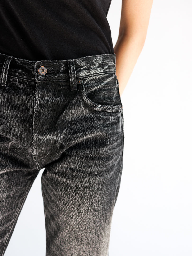 Close-up back view of the fit model in the B O R O デニム (BORO DENIM) 'Paint it Black' Tokyo jeans, highlighting their mid-rise and straight-leg silhouette for a snug fit around the hips and thighs